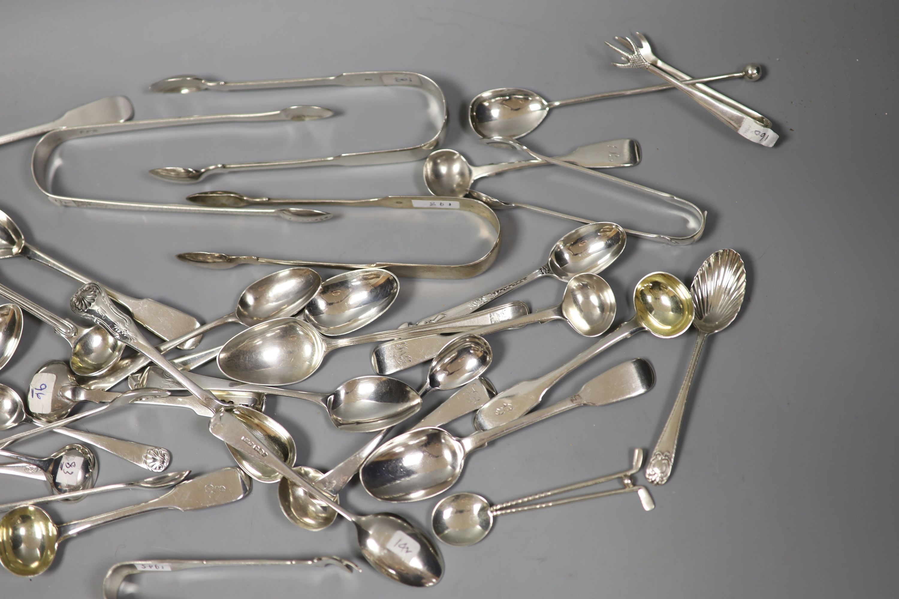 A quantity of assorted silver flatware including Georgian and later sugar tongs, condiment spoons etc.18oz.